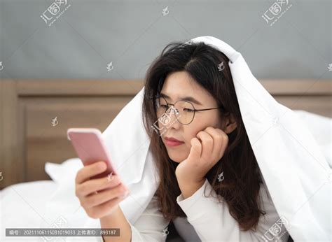 懒散的中国女孩床上玩手机,生活场景,人物百态,摄影,汇图网www.huitu.com