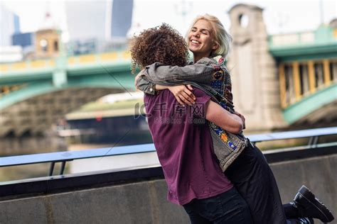 幸福的情侣在伦敦泰晤士河上的南华克桥附近拥抱高清摄影大图-千库网