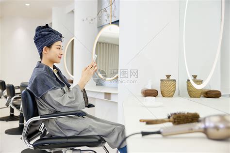 理发店洗完头的女性玩手机高清图片下载-正版图片502380219-摄图网