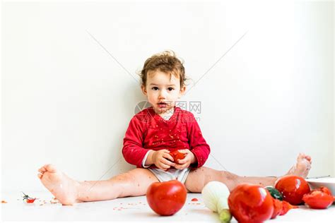一个赤脚的婴儿在吃番茄时玩耍高清图片下载-正版图片306092862-摄图网
