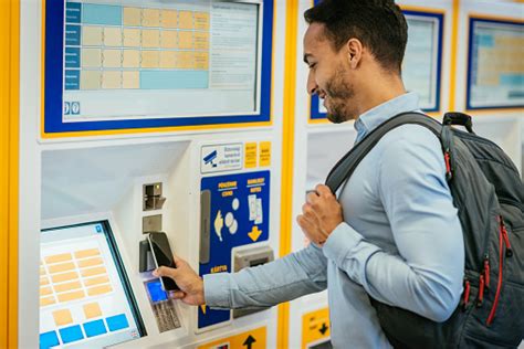 People buying rail tickets from a self service ticket booth, Waterloo ...