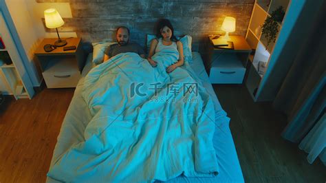 年轻的妻子和她的丈夫在床单下高清摄影大图-千库网
