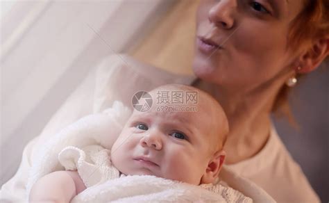 妈怀里抱着一个刚出生的婴儿女孩在窗前抱着一个婴儿母亲高清图片下载-正版图片506236649-摄图网