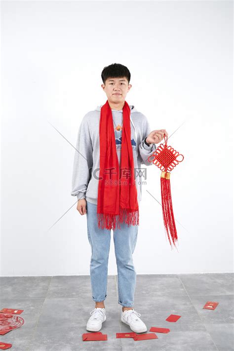 过年新年男生拿着中国结站着摄影图配图高清摄影大图-千库网