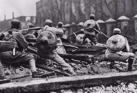 武汉会战的真实拍摄图片，士兵在打仗，灰色的黑白图片，当兵的拿枪趴在地上背着竹帽子。|ZZXXO