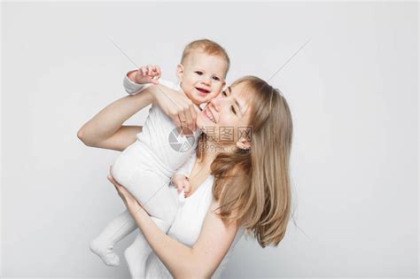 快乐美丽的年轻母亲吻站在白色高清图片下载-正版图片503063004-摄图网