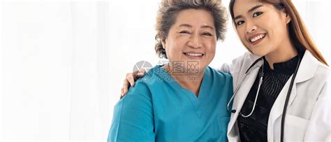 身穿制服的年轻女医生在去院看病时拥抱和微笑年老的女病人高清图片下载-正版图片306014840-摄图网