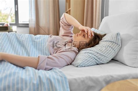 人、就寝时间和休息的概念-早上躺在家里床上的昏昏欲睡的少女。高清摄影大图-千库网
