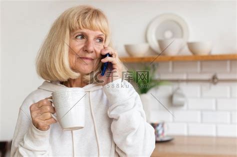 老妇人在家边喝咖啡边打电话高清摄影大图-千库网