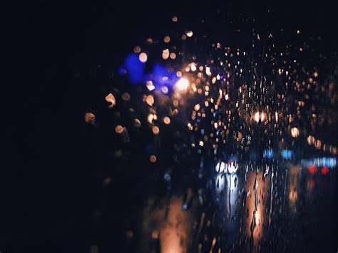 宁静的夜晚阴雨绵绵窗户上被雨水沾湿模糊了外面的光线