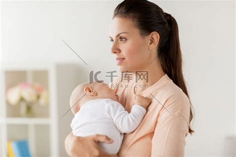 家庭、母性和人的概念——母亲抱着熟睡的小男婴在家。母亲抱着熟睡的婴儿高清摄影大图-千库网
