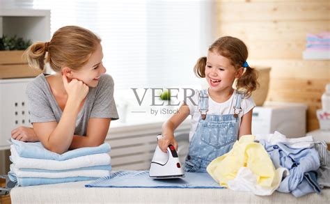 幸福的家庭，母亲，家庭主妇和孩子女儿在洗衣熨烫衣服照片摄影图片_ID:300828636-Veer图库