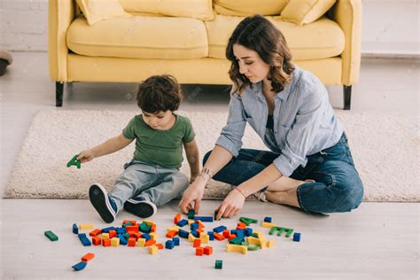 母亲和儿子在地毯上玩玩具块高清摄影大图-千库网