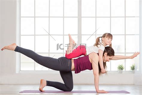 年轻的母亲和女儿做瑜伽运动高清摄影大图-千库网