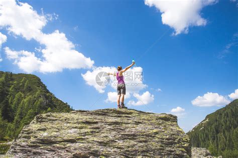 目标实现运动女孩站在一块大岩石上举起双手高清图片下载-正版图片305243231-摄图网