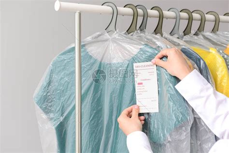 干洗店工人在衣服上贴标签高清图片下载-正版图片503748245-摄图网