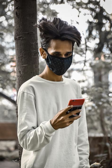 Boy using phone while wearing mask - PixaHive