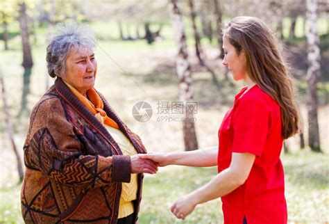 老妇人与年轻的看护人握手高清图片下载-正版图片507432995-摄图网